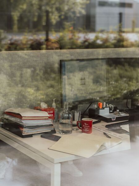 Foto van het bureau van een recruiter in Veurne, met een computer, notitieblok en andere kantoorbenodigdheden.